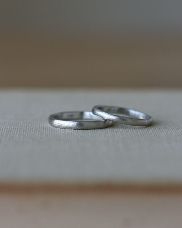 「王道のプラチナを、少し個性的に」と、
デザインされたおふたりの結婚指輪。

時間を重ねたような風合いのアンティーク加工は、
プラチナの輝きを活かしつつ、落ち着きのある印象に。

結婚指輪はこれから永く寄り添い、
さらにおふたりらしい指輪へと、
時間をかけて変化していきます。

少し艶が出たり、経年の使用感が出たり。
そんな過程も楽しんでいただけると嬉しいです。
 
　
》左側
地金：Pt900
幅：2.5mm
仕上げ：アンティーク
形：やわらか8角形
刻印：似顔絵刻印+手書き刻印

》右側
地金：Pt900
幅：2~2.3mm
仕上げ：アンティーク
形：やわらか8角形
刻印：似顔絵刻印+手書き刻印
　
　
　
　
uchimari